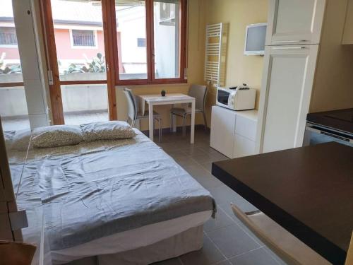 a room with a bed and a kitchen with a table at Casa di Gabriella in Grado