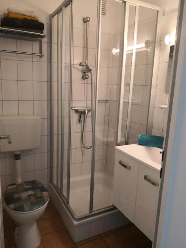 a bathroom with a shower and a toilet at Appartementhaus Martel - Adults Only in Travemünde