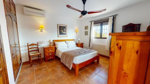 - une chambre avec un lit et un ventilateur de plafond dans l'établissement Villa Limonero by Family Homes, à Jávea