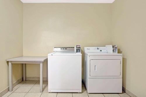 a kitchen with a stove and a refrigerator and a table at Microtel Inn & Suites by Wyndham Houston/Webster/Nasa/Clearlake in Nassau Bay