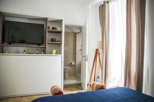 een slaapkamer met een televisie en een badkamer met een toilet bij Brezza Marina B&B in Barletta