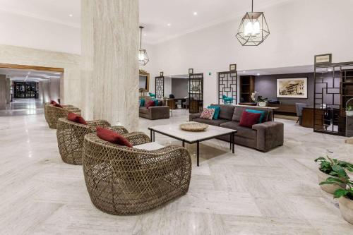 a living room with couches and chairs and a table at Ramada Plaza by Wyndham Leon in León
