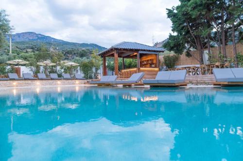 a swimming pool with chairs and a gazebo at Alissachni SeaSide Hotel in Derveni
