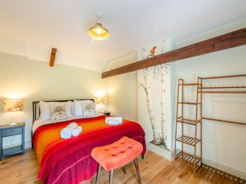 a bedroom with a bed with two orange chairs at Seascape Cottage in South Creake