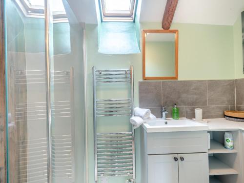 a bathroom with a shower and a sink and a mirror at Seascape Cottage in South Creake