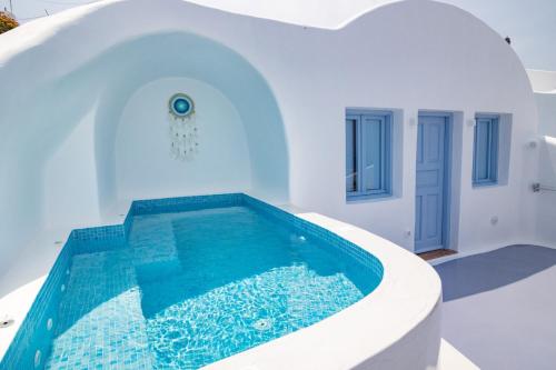a house with a swimming pool in the middle of a house at Sun Angelos Oia - Luxury Cave Suites in Oia