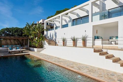 een huis met een zwembad voor een huis bij Villa Larosa with seaview in Es Cubells Ibiza in Es Cubells