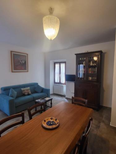 a living room with a table and a blue couch at Villa Torricelli Scarperia - Il Giardinetto Residence in Scarperia