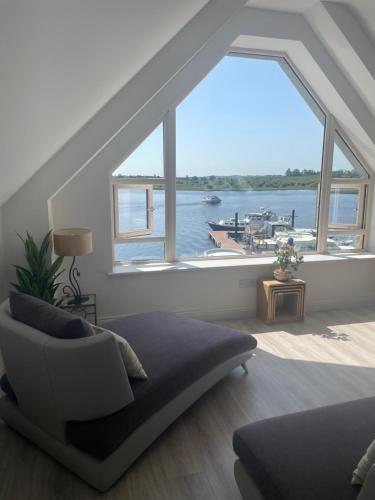 a living room with a large window overlooking a harbor at Lough Key Luxury Riverfront Apartment in Cootehall