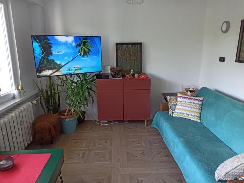 a living room with a blue couch and a flat screen tv at Mieszkanie Antoni in Głuchołazy