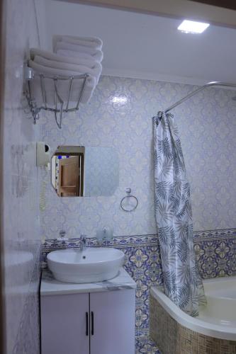 baño con lavabo y cortina de ducha en Bukhara Baraka Boutique Hotel, en Bukhara