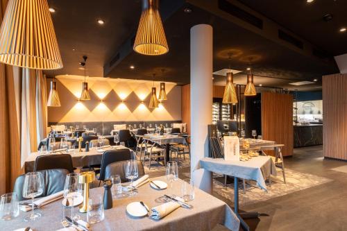 a restaurant with tables and chairs and chandeliers at Hotel Weißes Ross in Kulmbach