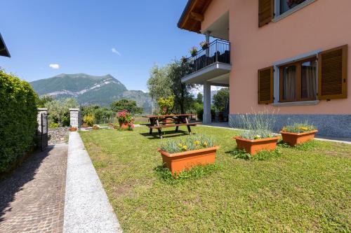 a backyard with a picnic table and flowers in pots at Apartment with garden and parking in Bellagio