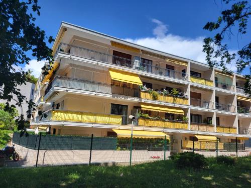 戛纳Cosy Studio à Cannes 8 min de la Croisette的公寓大楼设有黄色的阳台和围栏