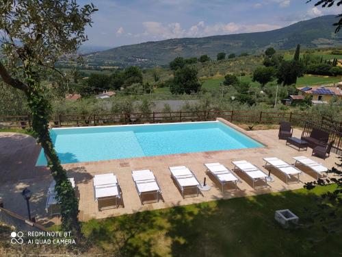 a swimming pool with chaise lounges and lounge chairs at Azienda Agrituristica Il Moraiolo in Foligno