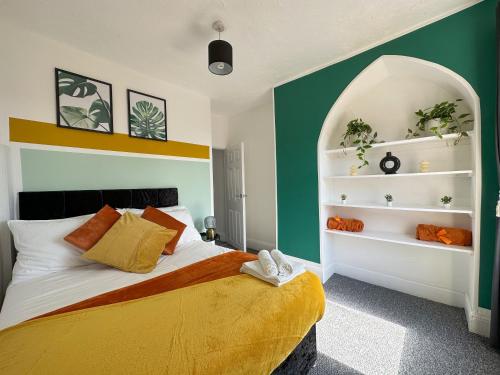 ein Schlafzimmer mit einem Bett mit einer grünen und weißen Wand in der Unterkunft Air Host and Stay - Phillimore - sleeps 9, mins from city free parking in Liverpool