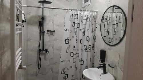 a bathroom with a shower curtain and a sink at Terkhena in Kazbegi