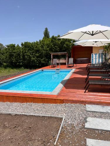 a swimming pool with chairs and an umbrella at Brewery House&Beer Spa in Aspindza