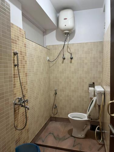 y baño con aseo y ducha. en Hotel Palbheu Inn, en Namchi