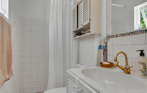 een witte badkamer met een wastafel en een toilet bij Lovely Home In Hornbk With Kitchen in Hornbæk