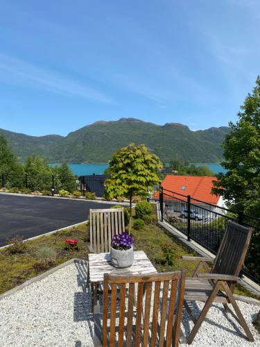 two wooden chairs and a table with flowers on it at Havn i Etne with fjordview in Etnesjøen