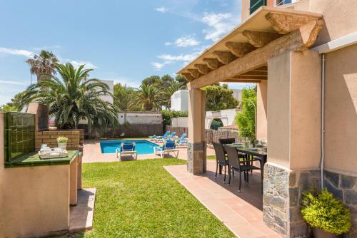 a patio with a table and chairs and a pool at Villa Laurax in Son Carrio