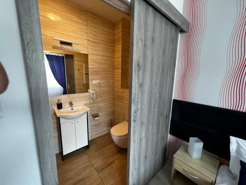 uma casa de banho com um lavatório branco e um WC. em Villa Mors em Mielno