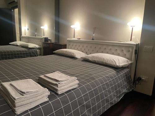 1 dormitorio con 2 camas y toallas. en Villa I tre Cipressi en Lido di Camaiore