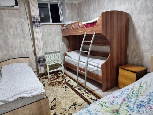 a bedroom with two bunk beds with a ladder at Hostel Sulaiman-Too in Osh