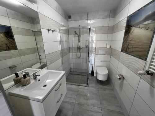 a bathroom with a sink and a shower and a toilet at Villa Mors in Mielno
