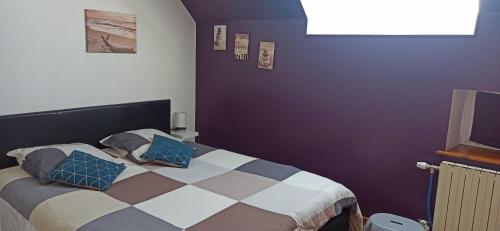 une chambre avec un lit avec des oreillers bleus dessus dans l'établissement Belle Longère, à Campeaux