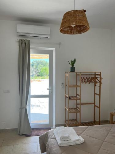 オストゥーニにあるTrullo Moiのベッドルーム1室(ベッド1台、窓、ファン付)が備わります。