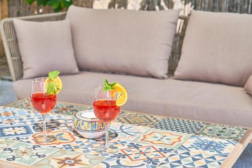 a table with three wine glasses on a table with a couch at Villa La Gitana in Anacapri