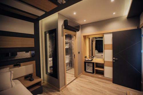 een kamer met een bed en een badkamer met een wastafel bij Burhaniye Marina Boutique Hotel in Burhaniye