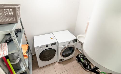 a laundry room with a washing machine and a toilet at Penzion V Údolí in Hodkovice nad Mohelkou