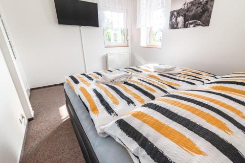 a bedroom with a bed with a striped blanket at Penzion V Údolí in Hodkovice nad Mohelkou