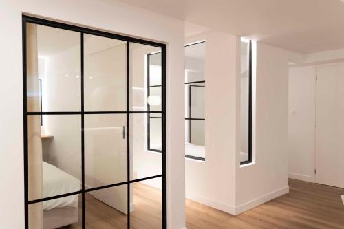ein Glasschrank in einem weißen Zimmer mit Holzböden in der Unterkunft Underground Luxury Living in Karystos