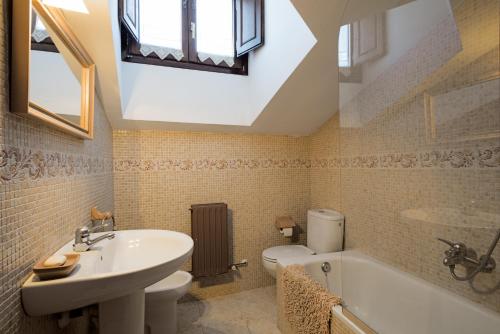 a bathroom with a sink and a toilet and a bath tub at Casa Rural Martínez in Peñacoba