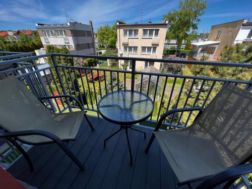 a balcony with two chairs and a table and a fence at Villa Mors in Mielno