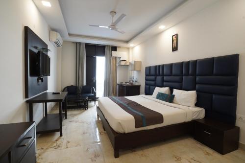 a bedroom with a large bed and a desk and a room at Park Studio DLF Phase 2, Cyber City, Gurgaon in Gurgaon