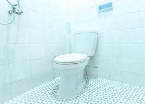 La salle de bains blanche est pourvue de toilettes et d'une baignoire. dans l'établissement Senggigi hill view homestay, à Senggigi