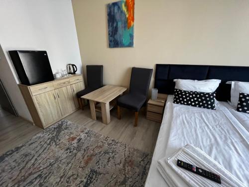a bedroom with a bed and a table and a chair at Villa Mors in Mielno