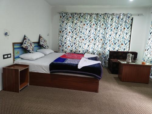 Un pat sau paturi într-o cameră la Tip Top Pahalgam