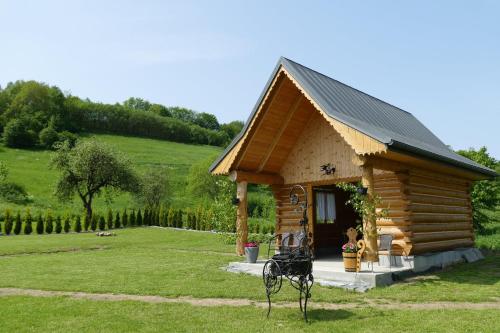a small log cabin with a bench in front of it at Domek przy Lubaniu in Ochotnica Dolna