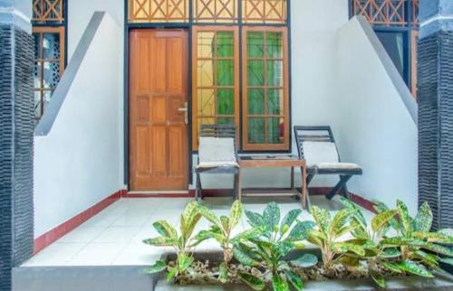 une maison avec une porte en bois et quelques plantes dans l'établissement Senggigi hill view homestay, à Senggigi