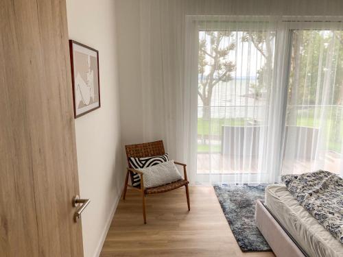 - une chambre avec un lit, une chaise et une fenêtre dans l'établissement Platan Garden Beach Balatonboglár 101, à Balatonboglár