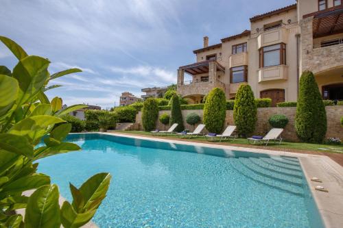uma piscina em frente a um edifício com uma casa em Villa Marina, Sea View Luxury Villa em Mati