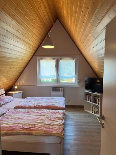 ドルム・ノイフェルトにあるFerienhaus Vogel - Dorum Neufeld - Nordseeのベッドルーム1室(ベッド1台、窓2つ付)