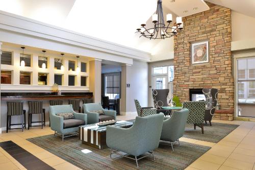 a lobby with chairs and tables and a fireplace at Residence Inn by Marriott Denver Airport at Gateway Park in Aurora