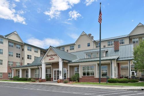 an exterior view of a hotel with an american flag at Residence Inn by Marriott Denver Airport at Gateway Park in Aurora